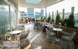 People sitting out on a rooftop terrace conversing
