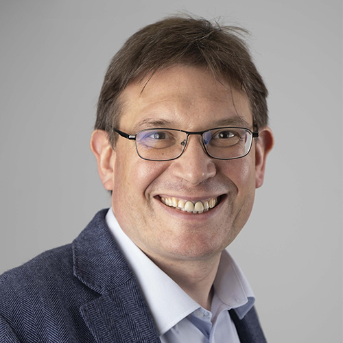 A square head and shoulders photograph of RCGP Executive Mark Thomas wearing a suit and blue tie.