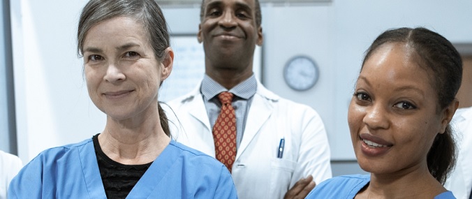 Three doctors in scrubs smiling