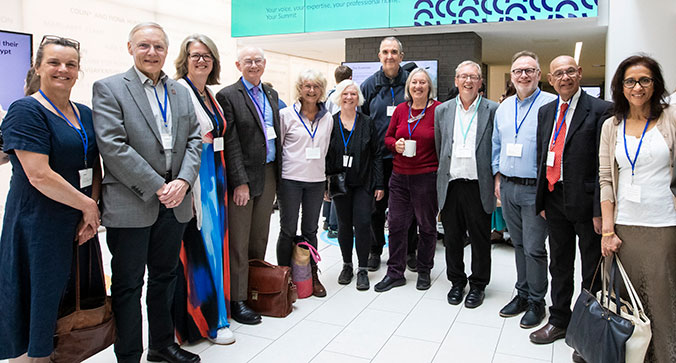 A group of people standing in a semi circle, all smiling. 