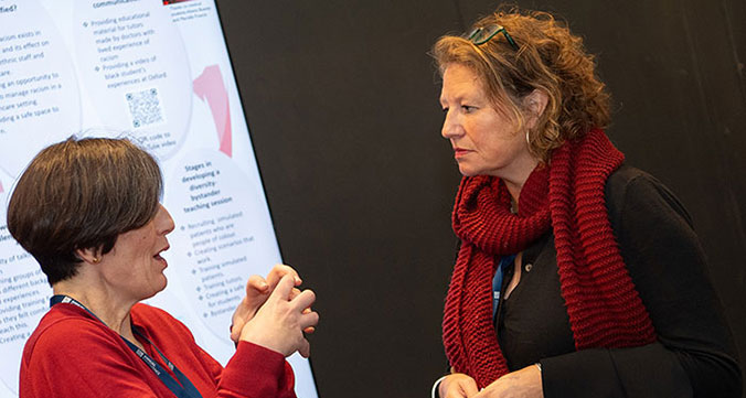 Conference delegates engaged in knowledge sharing at poster display.