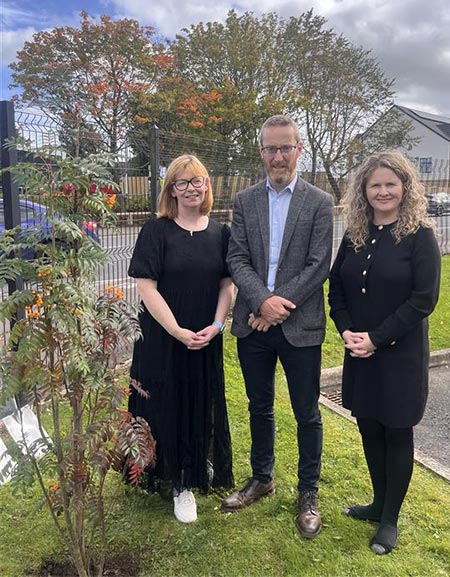 Image of Emma Murtagh with man and woman planting a tree in a park