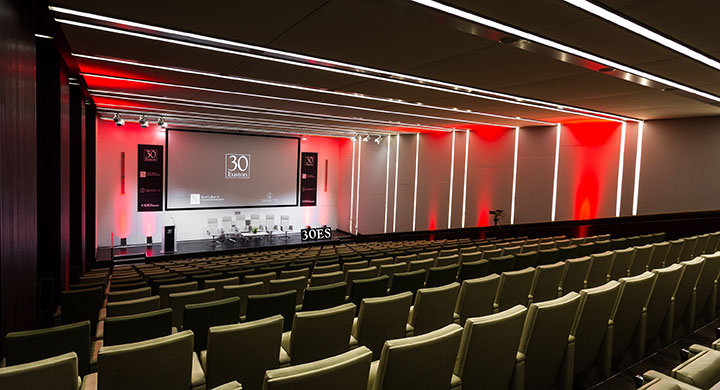 A wide shot of the RCGP auditorium, with lines of seats and a red lighting scheme.