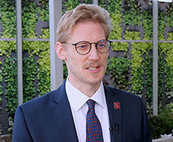 Headshot of Dr Munro Stewart wearing glasses and blue suit