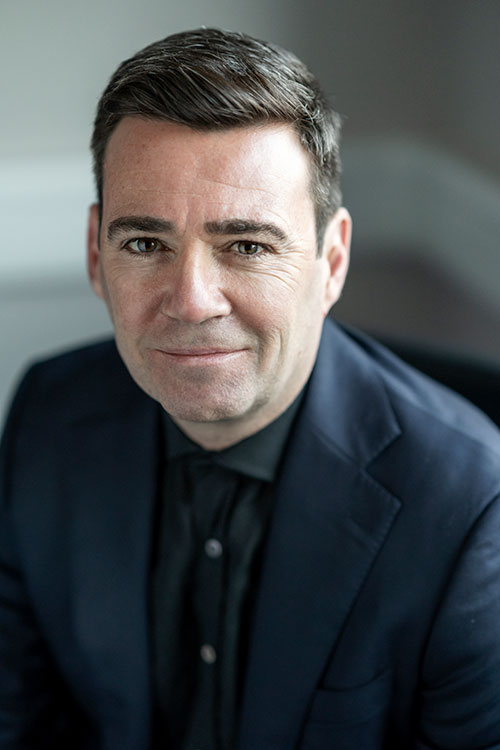 Portrait image of Andy Burnham, Mayor of Manchester. Wearing grey suit. 