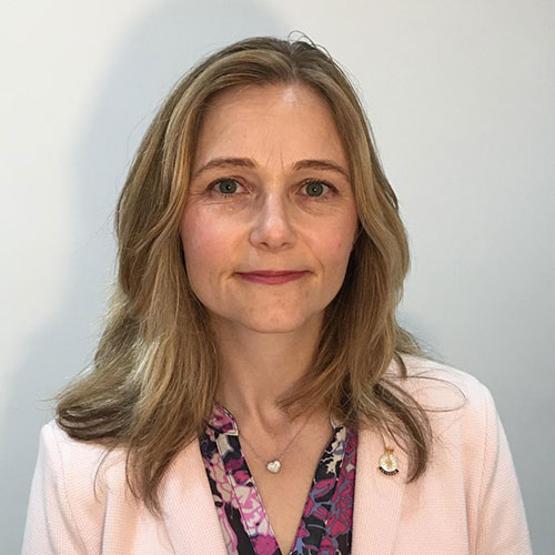 Headshot image of Dr Emily Brooks, wearing pink blazer 