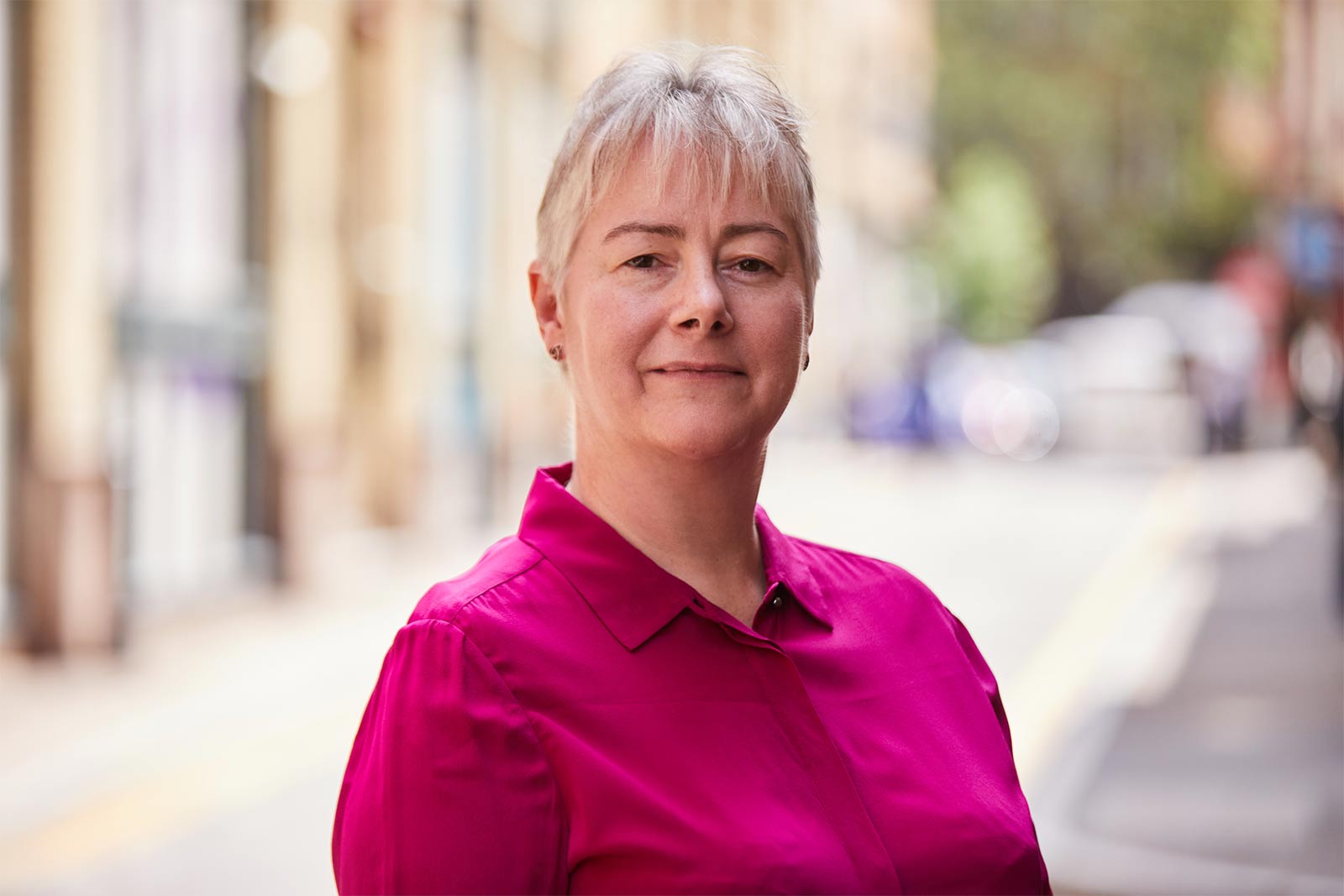 A photo of Dr Jeanette Dickson standing outside wearing a dark pink shirt.