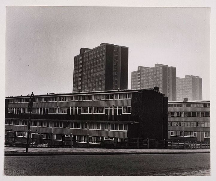 Black-and-white photo of 1960s council housing: low-rise flats in front, tall tower blocks behind, under a grey sky.
Gateshead council housing, 1963 (Henry Grant/London Museum)