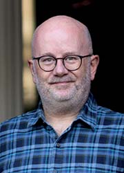 A small card image of Dr Ewen Stewart smiling at the camera.