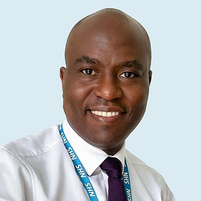 A head and shoulders shot of Dr Serge Engamba wearing a white shirt and a blue NHS lanyard around his neck. 
