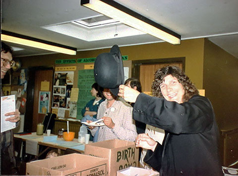 Sylvia Hikins and the ‘Birth Box’ at the UB40 Fair at Princes Park Health Centre, 1983. The Birth Box gave visitors a chance to be ‘born again’, based on the statistics of the area. On drawing a ticket, the visitor was told how where they were born and what they earnt would impact on how healthy they were 