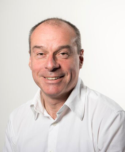Headshot of Dr Tom Coffey wearing white shirt